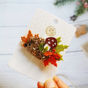 Detailed view of handmade felt hair clips with mushroom and hedgehog fall motifs