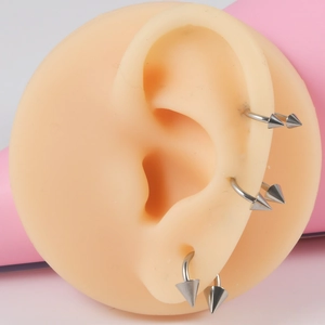 Silver G23 titanium horseshoe rings with spikes shown on silicone ear model