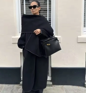 Close-up of premium black wool texture on loose silhouette coat with scarf detail