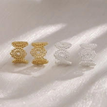 Detailed close-up of hollowed-out lace pattern earrings in gold and silver finish