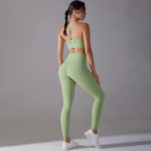 Detail view of light green high-waist yoga pants and criss-cross back sports bra