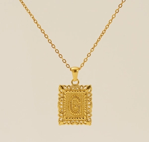 Gros plan détaillé du pendentif lettre G rectangulaire en or 18 carats avec gravures