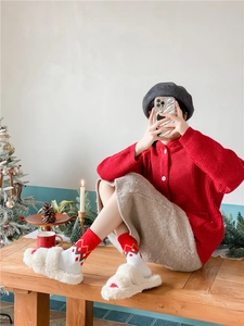Détails de chaussettes de Noël en polaire corail et pantoufles douces en décor de fête