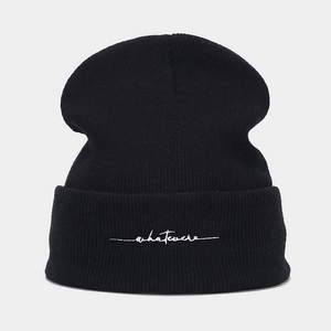 Close-up of whatever letter embroidery on black knitted beanie with ribbed texture