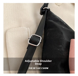 Detail of adjustable black strap with silver buckle on a stylish versatile handbag
