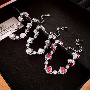 Detailed view of silver heart-shaped bracelets with pink and red zircon stones