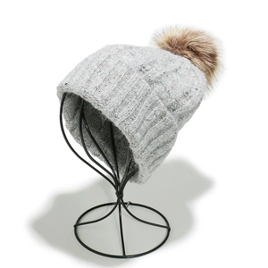 Close-up of light grey ribbed knit beanie with a large brown faux fur pom pom