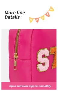 Détail de la trousse de voyage rose avec fermeture éclair dorée et écussons en chenille