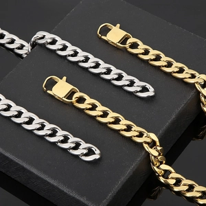 Macro shot of gold and silver cuban link chains with lobster clasps on a luxury jewelry box
