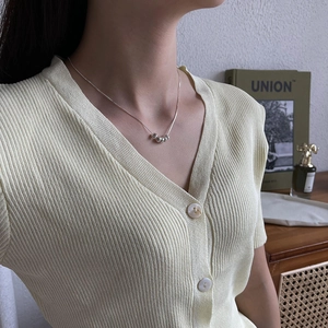 Detail view of a minimalist S925 silver snake chain necklace with five small silver beads