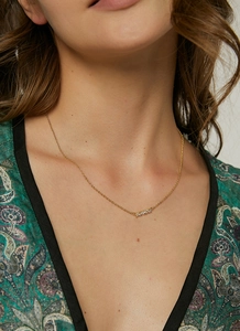 Close-up of elegant gold necklace featuring shimmering white zircon stones on a model