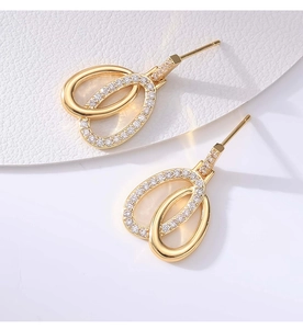 Detail of gold double oval earrings featuring sparkling pavé zircon settings