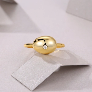 Close-up of a gold S925 silver ring featuring a smooth sphere set with a tiny moissanite