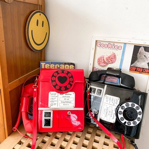 Detail of red and black retro telephone cross-body bags with shiny patent leather finish