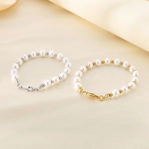 Elegant white freshwater pearl bracelets with gold and silver beads on beige silk fabric
