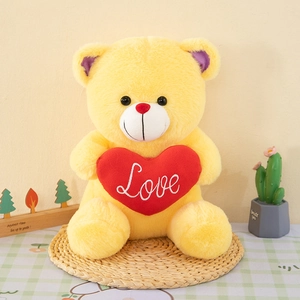 Yellow teddy bear plush toy holding a red heart with Love embroidery detail