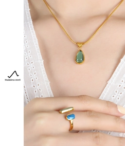 Detailed shot of vintage gold stainless steel necklace and ring with colorful stones