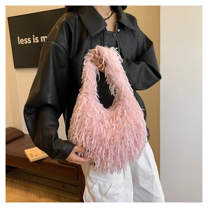 Detail of pink faux fur shoulder bag featuring soft plush texture and fringe tassels