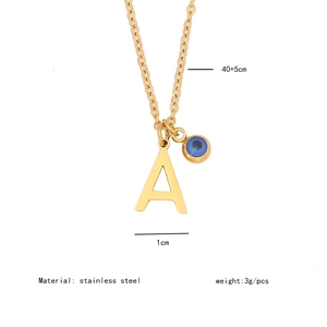 Détail du collier doré en acier inoxydable avec pendentif lettre A et œil bleu