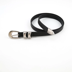 Detail of slim black leather belt with silver buckle, metal loops and sleek end tip