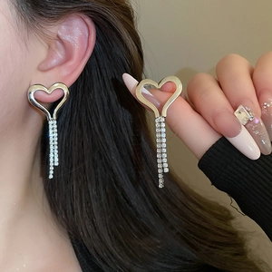 Elegant silver heart earrings with sparkling tassel fringe worn by a fashion model