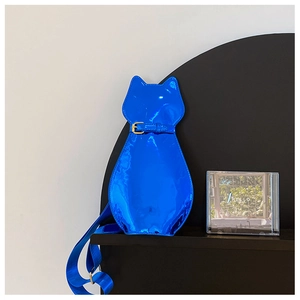 Detail of glossy electric blue cat-shaped crossbody bag with gold metallic buckles
