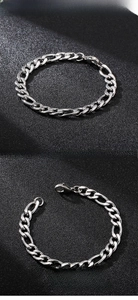 Macro shot of silver stainless steel Figaro chain bracelet with lobster clasp closure