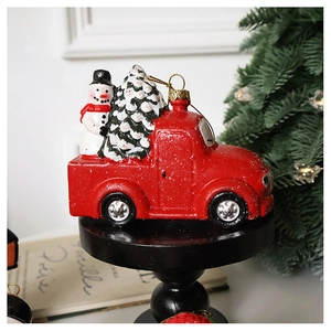 Detail of vintage red truck Christmas ornament with snowman and snowy tree decoration