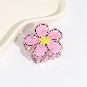 Detail view of pink and yellow floral hair claw clip made of semi-transparent acrylic
