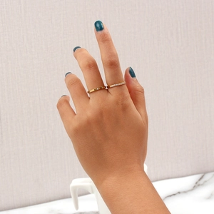 Ensemble de deux bagues en acier inoxydable plaqué or 18 carats avec zircon sur main