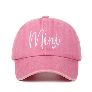 Close-up of pink washed cotton baseball cap with white Mini embroidery and heart detail