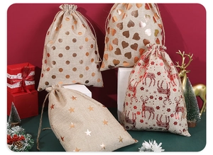 Detail of Christmas burlap drawstring gift bags with gold reindeer and star patterns