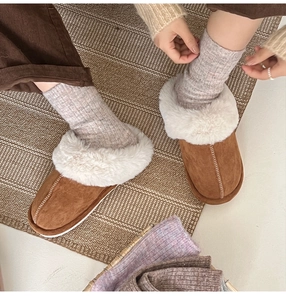 Top view of cozy brown suede slippers with white plush lining and knitted wool socks