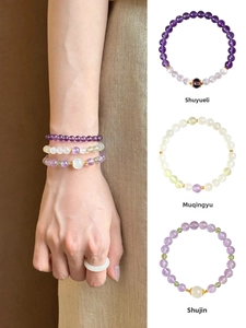 Detailed macro view of three layered natural amethyst and jade beaded stretch bracelets
