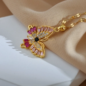 Elegant gold butterfly pendant necklace with colorful cubic zirconia on a white pedestal