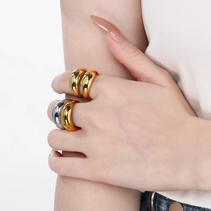 Close-up of thick dome rings in gold and silver finish with mirror-polished metal surface