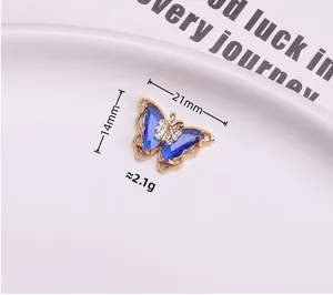 Macro shot of a gold butterfly pendant with blue translucent wings and tiny diamonds