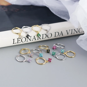 Macro shot of S925 silver flower hoop earrings with colorful zircon stones on book