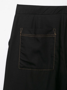 Detail of black twill blazer pocket with contrasting orange-brown double stitching