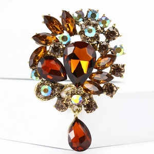 Macro detail of amber crystal flower brooch with vintage bronze alloy and colorful rhinestones