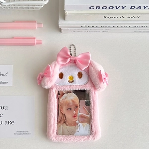 Pink plush bunny card holder with bow and chain shown on a desk with cute accessories