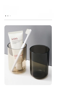 Detail showing amber and smoke grey translucent plastic toothbrush cups in a modern set