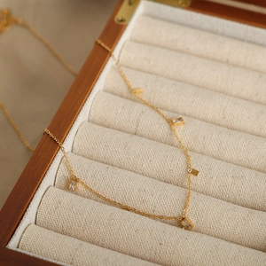 Golden titanium steel necklace with geometric zircon pendants in a wooden jewelry box