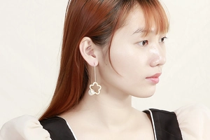 Close-up of elegant gold clover drop earrings with pearls on model for a stylish look