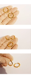Macro detail of gold bamboo joint hoop earrings showing texture and closure mechanism