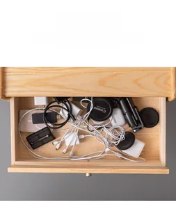 Cluttered wooden drawer with messy USB cables, chargers, and camera lens accessories