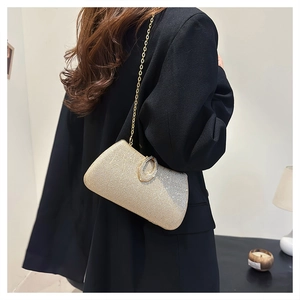 Chic gold glitter evening clutch bag with ring clasp shown on model in black suit