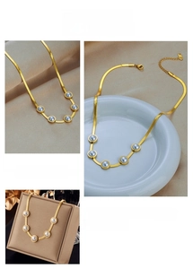 Dettaglio della collana a catena serpente dorata con perle su seta e ceramica