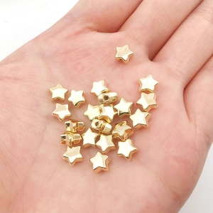 Macro view of gold star-shaped CCB beads held in hand for size and texture reference