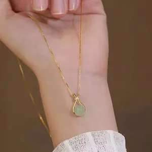 Collier élégant en or avec pendentif en jade vert et accents diamantés sur mannequin